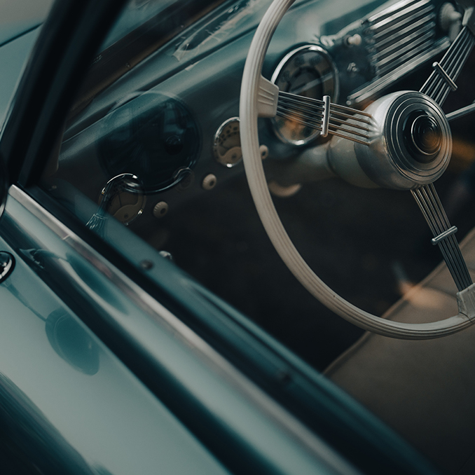 Oldtimer car dashboard. Retro car interior. Old steering wheel detail.