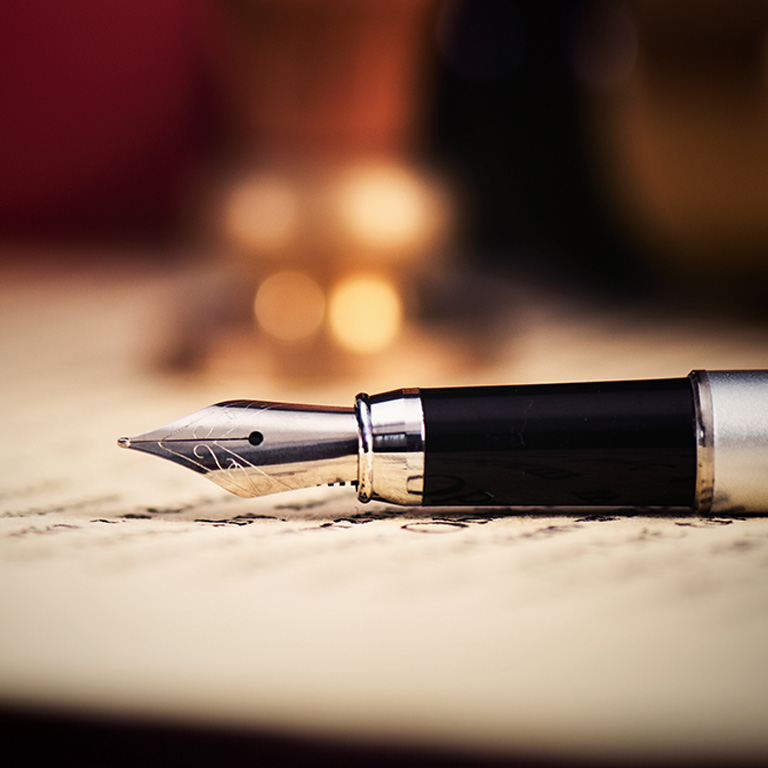 Close-up of a pen resting on a document related to legacy planning, with a blurred background.